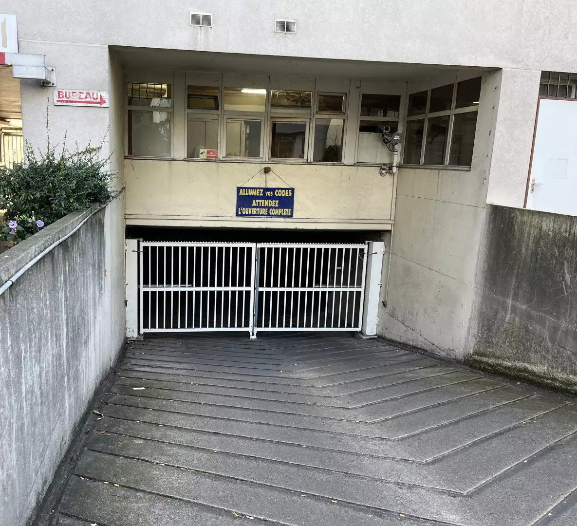Entrée du parking sécurisé avec grille pour véhicules